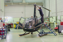 Hispanic Mechanic Working On Helicopter In Hangar