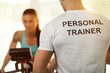 © luckybusiness - Personal trainer with woman on cycling machine at the gym