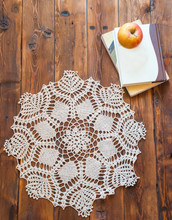 Knited Openwork Crochet Doily Lying On A Wooden Table. View From Above