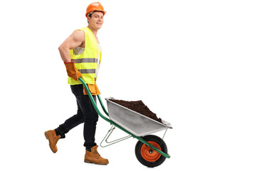 Wall Mural - Worker carrying dirt in a wheelbarrow