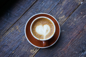 I Heart Coffee / A coffee cup with a popular 'heart' latte art is resting on a wooden table.