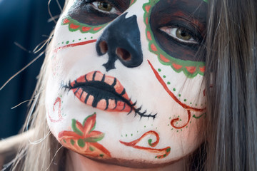 Portrait of woman with sugar skull face painting.