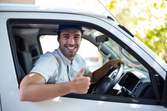 Cheerful delivery man showing thumbs up 