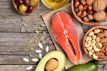 Selection of healthy fat sources on wooden table. Copyspace background. Top view. 