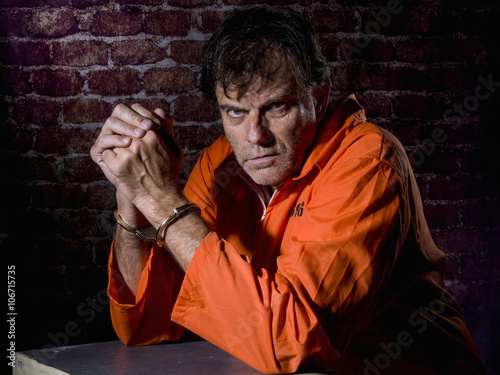 Fotografia Mature man, handcuffed and locked in prison, with gestures of repentance