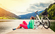 canvas print picture - woman with e-bike resting beside a beautiful lake-e-power 17