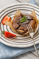 Wall Mural - Chocolate fondant  with strawberry and mint on the ceramic plate vertical