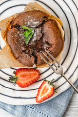 Wall Mural - Chocolate fondant  with strawberry and mint on the ceramic plate