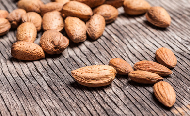 Wall Mural - Tasty almond nuts on rustic wooden background