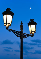 old street light and moon by night. 