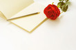 red rose on a notebook and pencil in vintage style