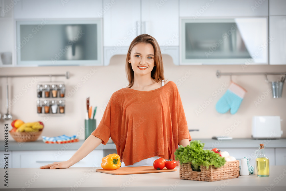 Young with with basket of fresh vegetables in the kitchen