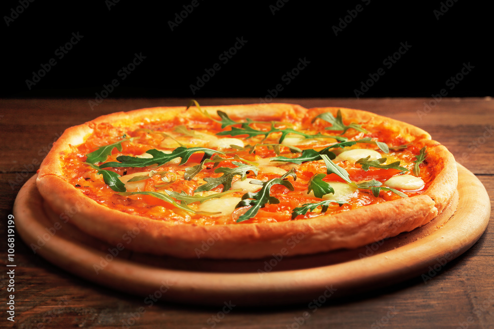 Margherita pizza with arugula on wooden table