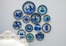 Porcelain Dutch Plates Placed On The Cement Wall As Background.