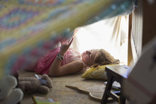 Caucasian Girl Reading In Blanket Fort