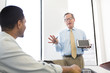 © Sam Diephuis/Blend Images - Businessman showing digital tablet to colleagues in meeting