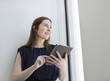 © Sam Diephuis/Blend Images - Caucasian businesswoman using digital tablet at office window