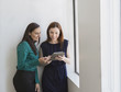 © Sam Diephuis/Blend Images - Caucasian businesswomen using digital tablet at office window