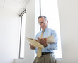 © Sam Diephuis/Blend Images - Caucasian businessman reading folder in office
