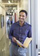 © Sam Diephuis/Blend Images - Black businessman holding folder in office hallway