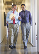 © Sam Diephuis/Blend Images - Businessmen using cell phone in office hallway