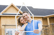 © Mike Kemp/Blend Images - Caucasian couple holding frame near house under construction