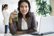 © JGI/Jamie Grill/Blend Images - Hispanic businesswoman drinking green juice at desk in office
