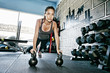 © Peathegee Inc/Blend Images - Woman planking with kettlebell in gym