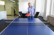 © Don Mason/Blend Images - Businessman playing table tennis in office