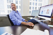 © Don Mason/Blend Images - Caucasian businessman working at computer in office