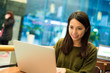 © leungchopan - Woman working on laptop computer in coffee shop
