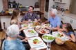 © WavebreakmediaMicro - Multi-generation family talking while having meal in kitchen