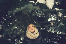 Caucasian Woman Standing Under Evergreen Tree Branches