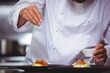 © WavebreakmediaMicro - Chef sprinkling spices on dish in commercial kitchen