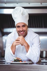 Wall Mural - Chef leaning on the counter with a dish