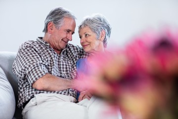 Wall Mural - Happy senior couple embracing each other on sofa