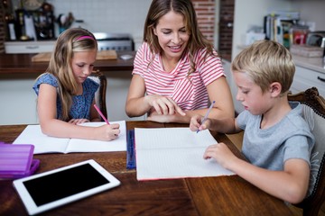 Wall Mural - Mother helping kids with their homework