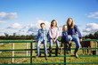 © Inti St Clair/Blend Images - Caucasian farmer and children sitting on fence on ranch