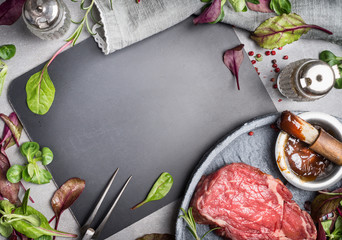 Wall Mural - Grill steak ingredients around  blank chalkboard. Grill or BBQ steak marinating with Barbecue sauce and basting brush on stone table background, top view.