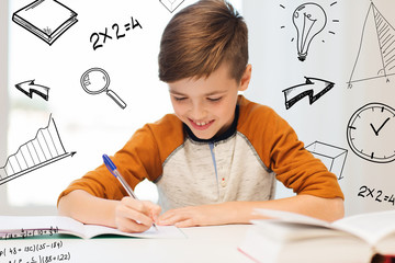 Canvas Print - smiling student boy writing to notebook at home