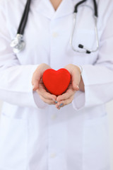 Wall Mural - Female doctor with stethoscope holding heart.  