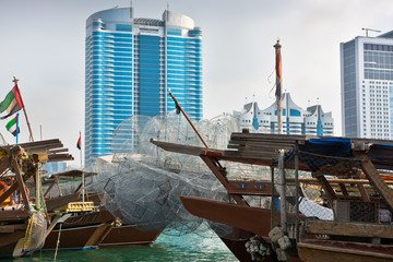 Canvas Print - Abu Dhabi buildings skyline with old fishing boats