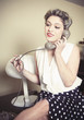 © Connect Images - Portrait of young woman wearing vintage clothes and talking on vintage phone