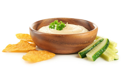 Wall Mural - Wooden bowl of tasty hummus with chips, parsley and cucumber, isolated on white