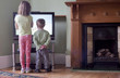 © Connect Images - Rear view of sister and brother standing too close to and watching TV