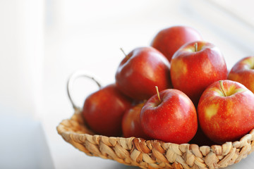 Wall Mural - Ripe red apples in a wicker basket on windowsill