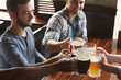© Africa Studio - Group of happy friends drinking beer in pub