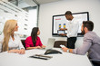 © Connect Images - Young business colleagues looking at digital table in meeting in conference room