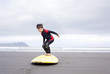 © Connect Images - Boy practicing on surfboard on beach