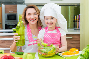 Wall Mural - Happy mother and daughter cooking a salad.